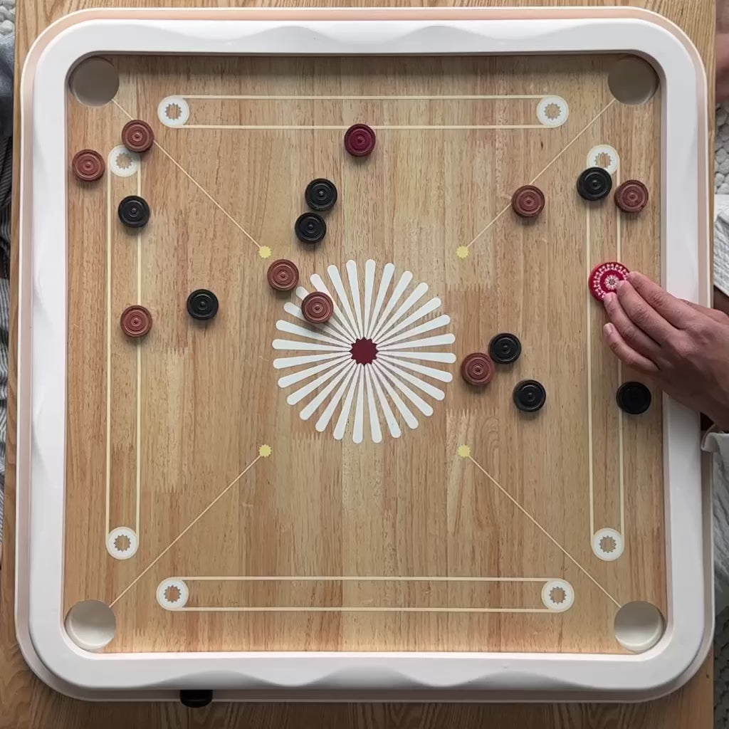 Carrom board video, person flicking a carrom striker across the surface of the carrom board.